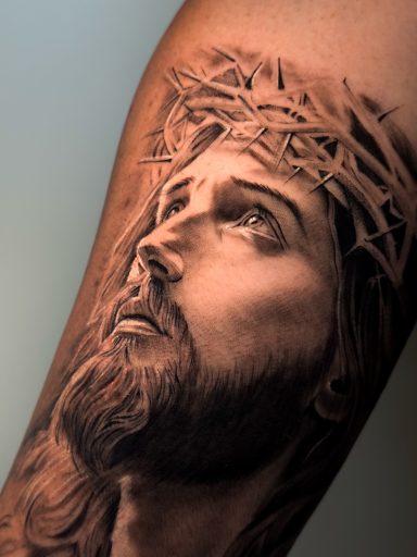 Retrato realista de Jesucristo con corona de espinas, mirando hacia arriba.